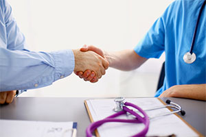 Male Medical Professional shaking another males hand.